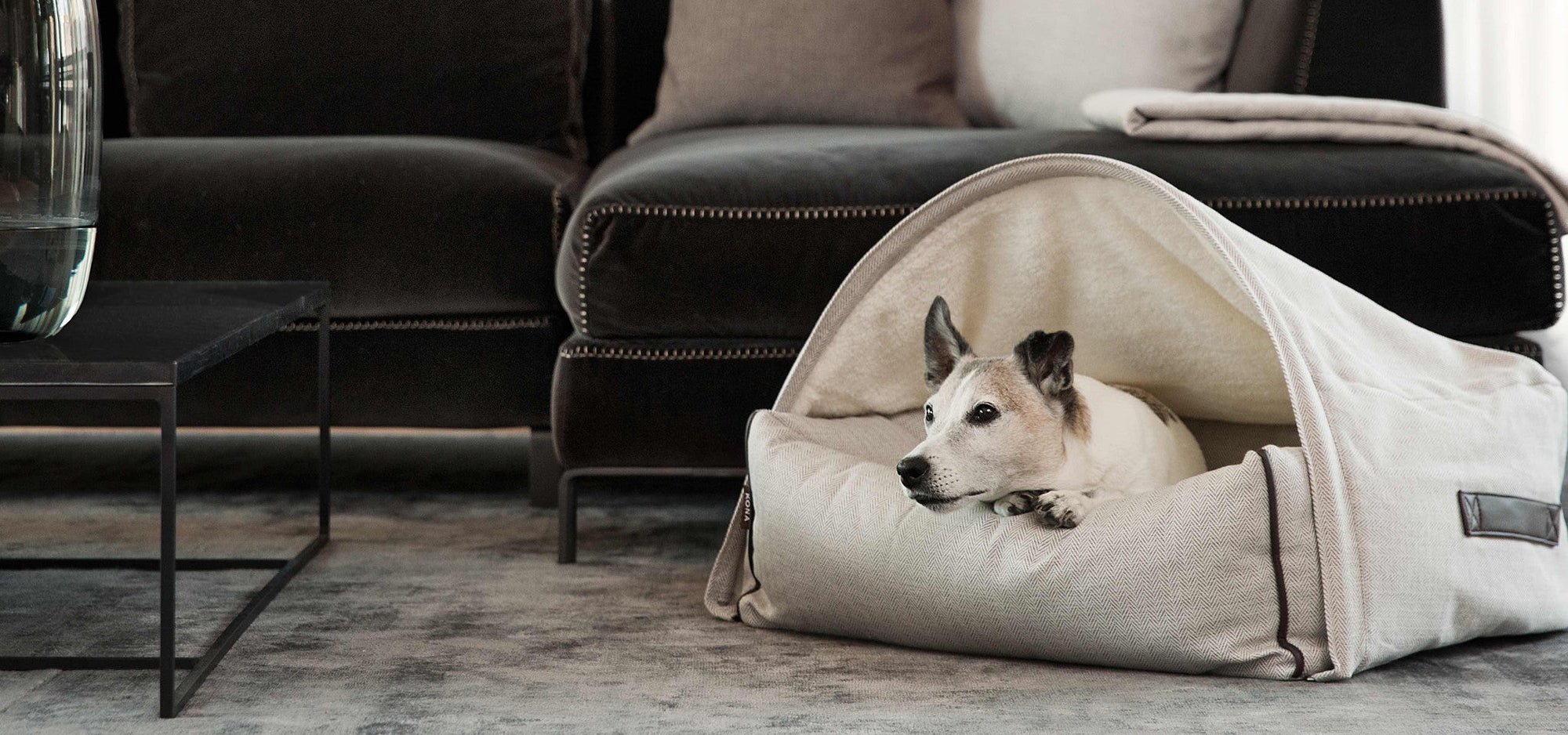 KONA CAVE- cosy dog cave bed in cream herringbone with adorable JRT dog. Stylish Italian Living room with Italian furniture. Elle Decor dog bed.