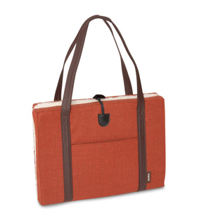 Luxury flooded KONA CAVE® dog mat used as a seat cushion for arenas. Folded  cushion with breathable lining and long shoulder straps for easy transportation. 