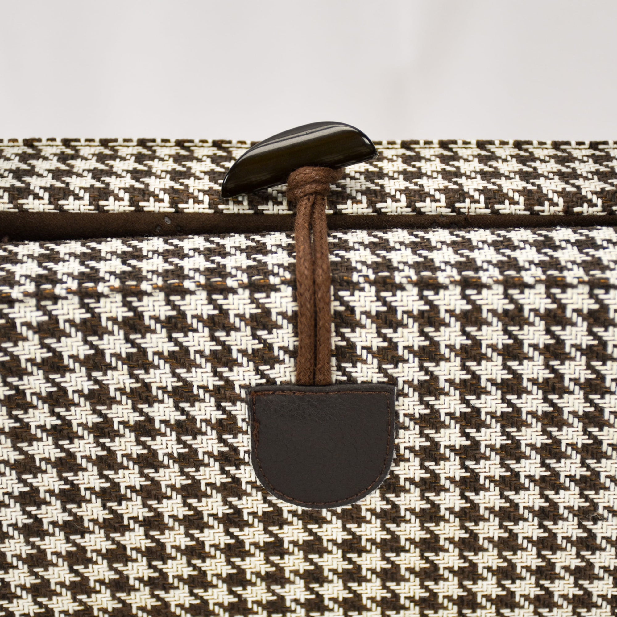 Close up of the convenient one-handed toggle closure in brown on the KONA CAVE® Travel  Dog Bed in Brown and White Houndstooth with Brown Quilted Alcantara Lining